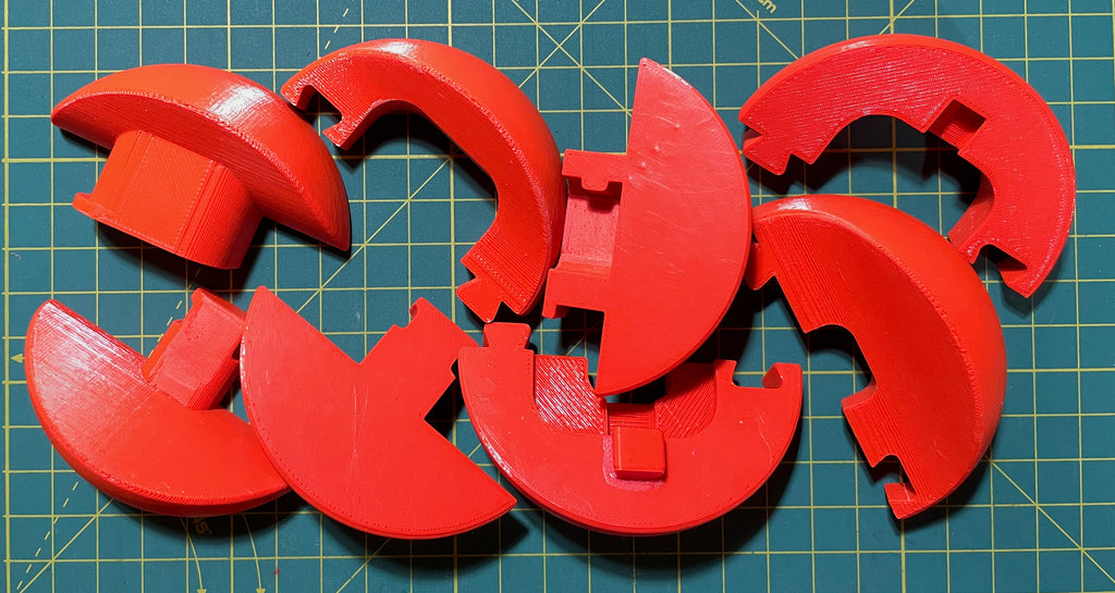Puzzle esférico 3D BKT de 7,5 cm en naranja flúor, con las piezas sueltas