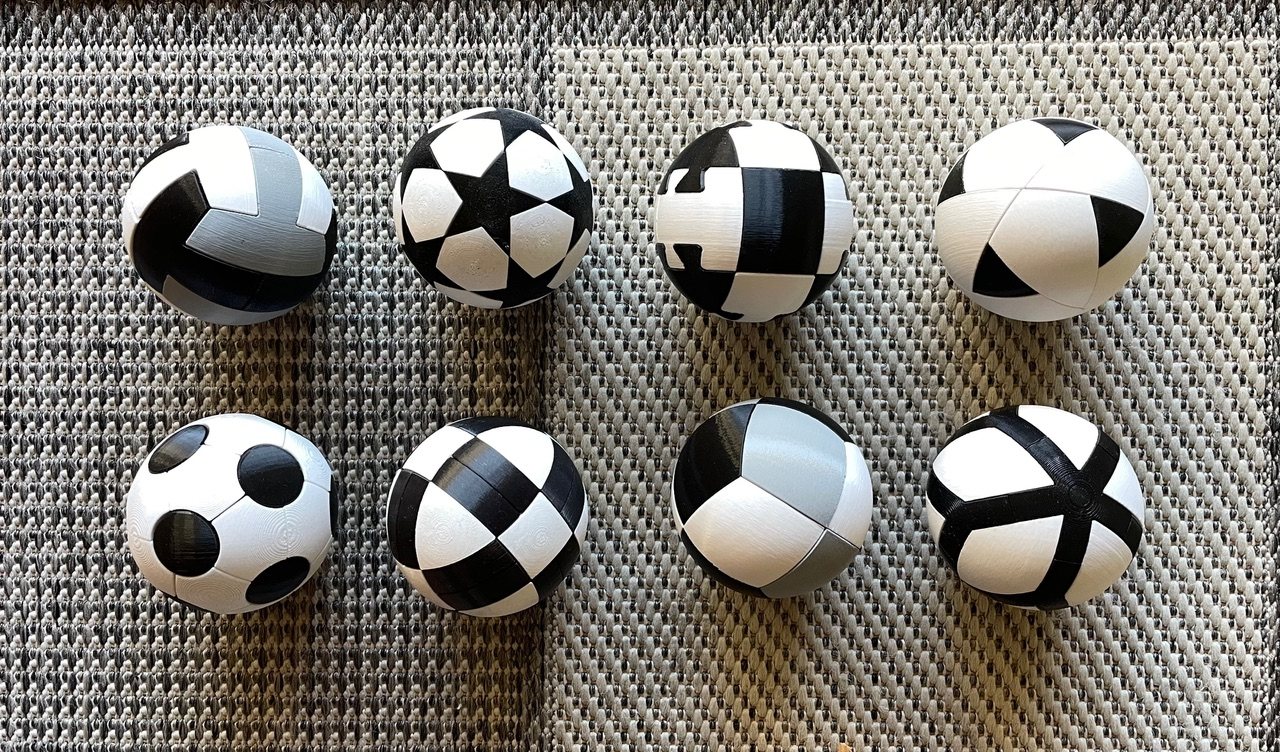 Ocho puzzles esféricos de Benpuz armados, en blanco, negro y gris